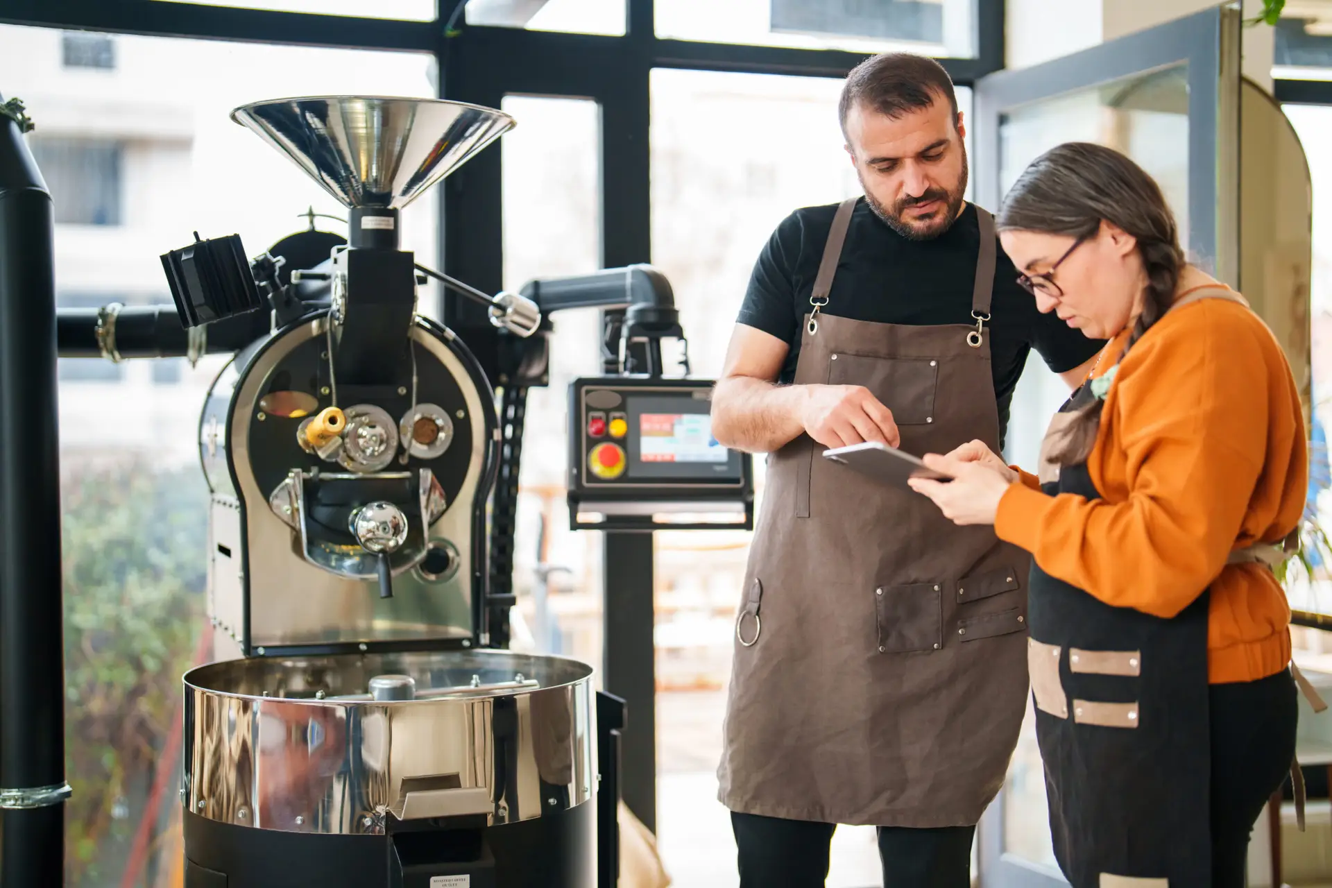 using digital tablet next to coffee roasting machine